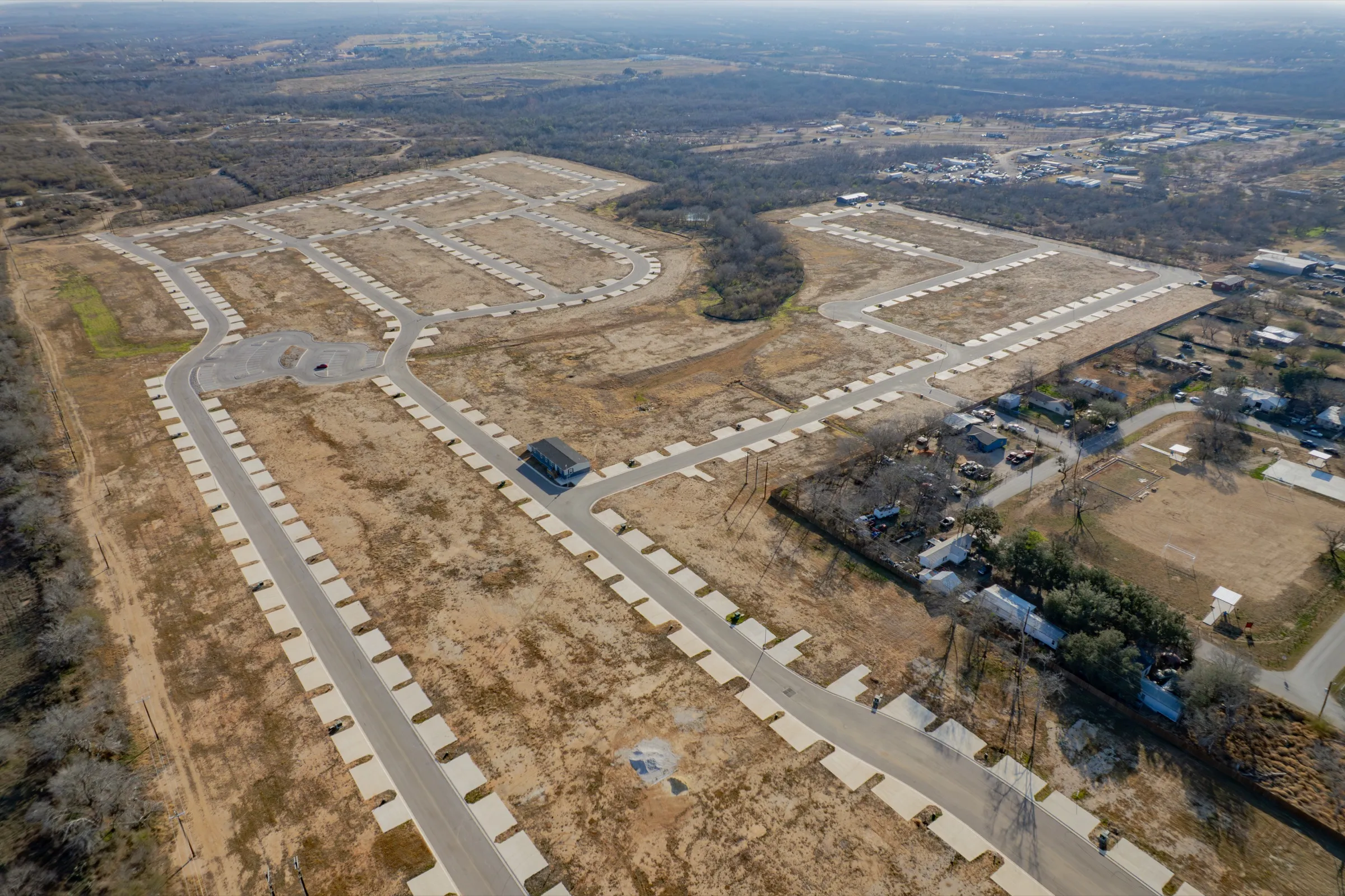 Aerial view of a new residential community with roads and lots under construction